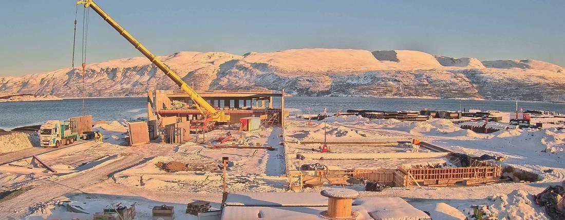Betongvegger reist på byggeplassen, fjell bak
