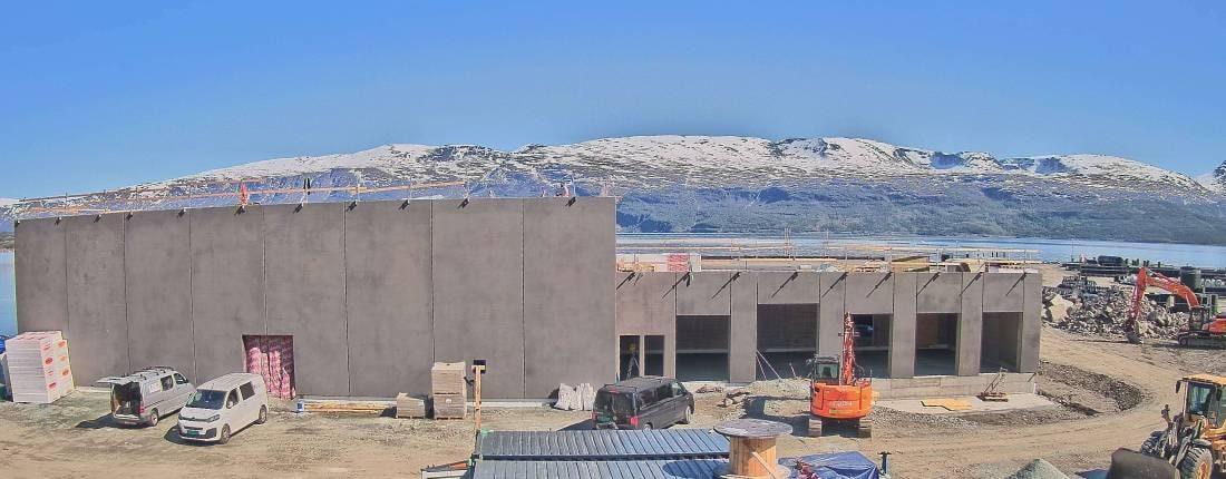 Høye betongvegger med fjorden og fjellene bak